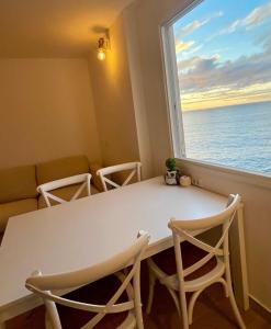 タコロンテにあるApartment Inside the wave Aのテーブル、椅子、海の景色を望む窓