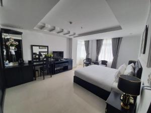 Habitación de hotel con cama y espejo en Kay Hotel Da Nang, en Da Nang