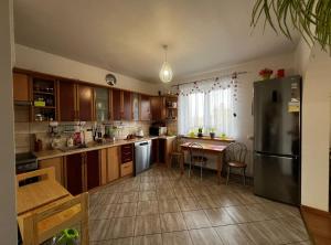a kitchen with wooden cabinets and a table and a refrigerator at Zielony Gaj in Gaj