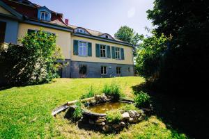 a large house with a pond in the yard at Villa Levin - 56qm, bis 4 Personen, free Wifi & parken 
