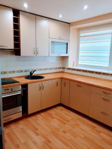 una cucina con armadi bianchi e lavandino di Apartments in the Sun CITY a Šiauliai