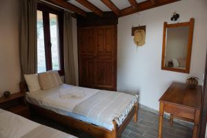 1 dormitorio con cama, espejo y mesa en Vida Balance Garden en Mithimna