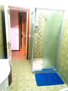 La salle de bains est pourvue d'une douche avec une porte en verre. dans l'établissement Da Piero e Gina, à Palidoro