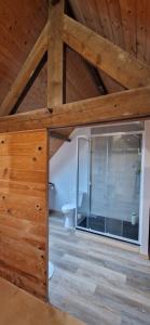 a room with a glass door in a wooden ceiling at Maison à la campagne. in Audembert