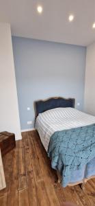 a bedroom with a bed and a wooden floor at Maison à la campagne. in Audembert