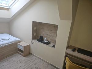 オストラヴァにあるHotel Taurusのベッドとデスクが備わる小さな客室です。