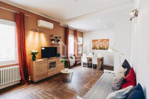 a living room with a television and a dining room at Gold Apartment in Ferrara