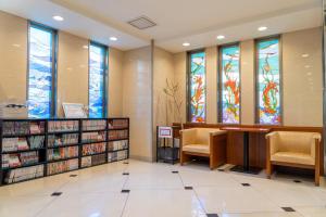 名古屋的住宿－名古屋金山名鐵旅館，一个带椅子和彩色玻璃窗的图书馆