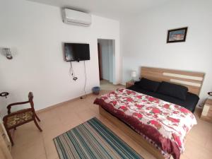 1 dormitorio con 1 cama y TV en la pared en Palmera Chalets Owners Best Vacation Group Families only, en Ain Sokhna