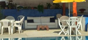 a group of white chairs and a table and a couch at Hostel Yellow House MG in Itamonte