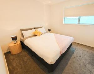 - une chambre avec un grand lit et une fenêtre dans l'établissement Waterloo Located New Modern Style, à Lower Hutt