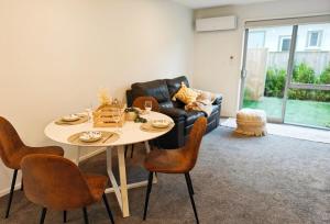 - un salon avec une table, des chaises et un canapé dans l'établissement Waterloo Located New Modern Style, à Lower Hutt