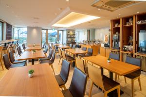 restauracja z drewnianymi stołami i krzesłami w obiekcie Meitetsu Inn Nagoya Kanayama w mieście Nagoja