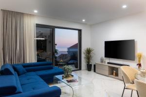 ドゥブロヴニクにあるLuxury Villa Ginaの青いソファとテレビのあるリビングルーム