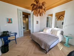 エッテン・ルールにあるBoutique B&B Villa van Vossのベッドルーム1室(ベッド1台、シャンデリア付)