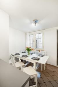 ein weißes Esszimmer mit einem weißen Tisch und Stühlen in der Unterkunft Beautiful Apartment in Old Town House City Center in Zürich