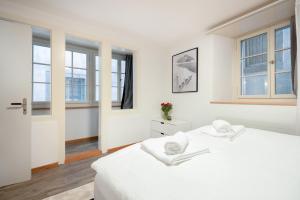 um quarto branco com 2 camas e janelas em Beautiful Apartment in Old Town House City Center em Zurique