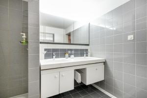 ein Badezimmer mit einem weißen Waschbecken und einem Spiegel in der Unterkunft Beautiful Apartment in Old Town House City Center in Zürich