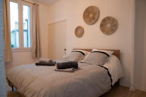ein Bett in einem Schlafzimmer mit zwei Hüten an der Wand in der Unterkunft Logement de charme en plein coeur d'Avignon in Avignon