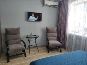 a room with two chairs and a table and a window at Smart Apartment на Соборной 23 in Kremenchuk