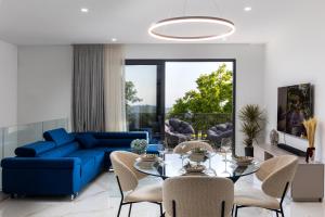 ドゥブロヴニクにあるLuxury Villa Ginaの青いソファとガラスのテーブルのあるリビングルーム