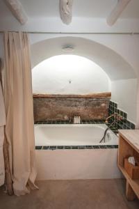 a bathroom with a bath tub and a shower curtain at ES CUCONS RURAL HOTEL in San Antonio