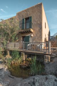 un bâtiment avec un balcon et un pont sur une rivière dans l'établissement ES CUCONS RURAL HOTEL, à Sant Antoni de Portmany