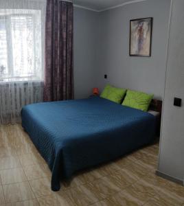 a bedroom with a blue bed and a window at Smart Apartment на Соборной 23 in Kremenchuk