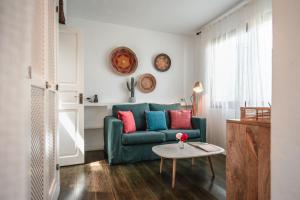 - un salon avec un canapé vert et une table dans l'établissement ES CUCONS RURAL HOTEL, à Sant Antoni de Portmany