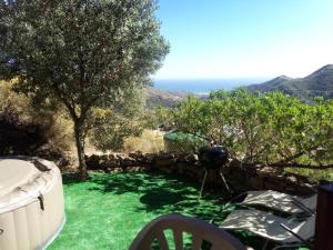 a garden with a stone wall and green grass at Romantic Mountain cabin with Spa in Caserío Carraspite