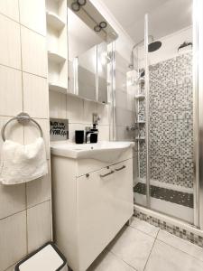biała łazienka z umywalką i prysznicem w obiekcie Studio Placa w mieście Punat