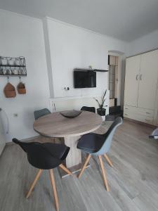 salon z drewnianym stołem i krzesłami w obiekcie Studio Placa w mieście Punat