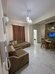 a living room with a couch and a table at DREAM APARTMENTS Saranda in Sarandë