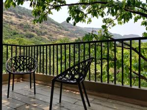 a bench and chair on a balcony with a view at The Marigold Villa in Pune