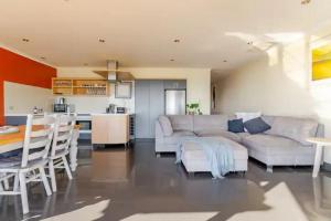 Il comprend un salon avec un canapé blanc et une cuisine. dans l'établissement Luxurious 3 bedroom beachfront - panoramic views, à Port Adelaide