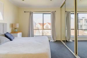 Port Adelaide的住宿－Luxurious 3 bedroom beachfront - panoramic views，一间卧室设有一张大床和大窗户