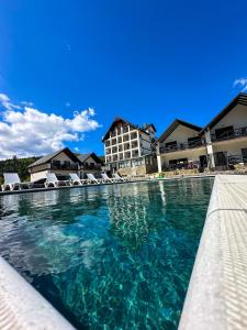 einen Pool in einem Resort mit Stühlen im Wasser in der Unterkunft Villa For You Hotel in Poljanyzja