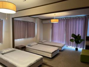 2 camas en una habitación con 2 ventanas en 南名駅貸切一軒家, en Nagoya