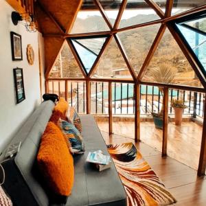 a living room with a couch and a large window at Glamping Ibanazk in Ibagué