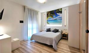 1 dormitorio con 1 cama y una pintura en la pared en Hotel Panorama, en Lido di Jesolo