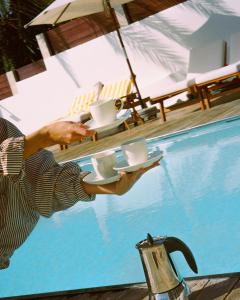 a man holding a tray of toilets in a swimming pool at UNIQUE Villas Lajares - Only Adults in Lajares