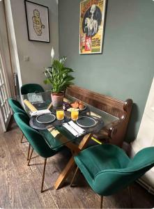 a dining room with a table and green chairs at Converted church in Beckenham