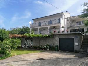 a large white house with a garage at Apartman TRALJE in Senj