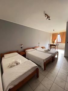 1 Schlafzimmer mit 2 Betten, einem Tisch und Stühlen in der Unterkunft Agriturismo San Giuliano dei fratelli Giai in Susa