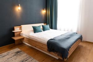 a bedroom with a bed with blue pillows and a window at Urban Six Apartments in Făgăraş