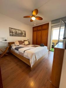 a bedroom with a bed and a ceiling fan at Alquilaencanarias Caletillas Vista al Mar in Candelaria
