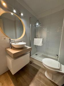 a bathroom with a sink and a toilet and a mirror at Alquilaencanarias Caletillas Vista al Mar in Candelaria