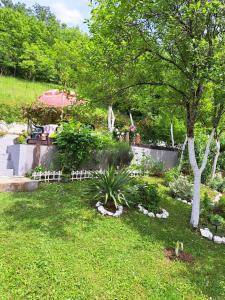 a garden with a fence and trees and grass at Seosko domacinstvo Halil in Ćukovi
