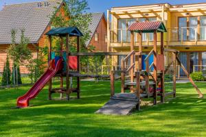 a playground with slides in a yard next to a building at Domki Apartamentowe Bravo in Bobolin