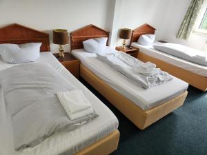 2 camas individuales en una habitación con 2 lámparas en Hotel Heidekrug in Pinneberg, en Appen